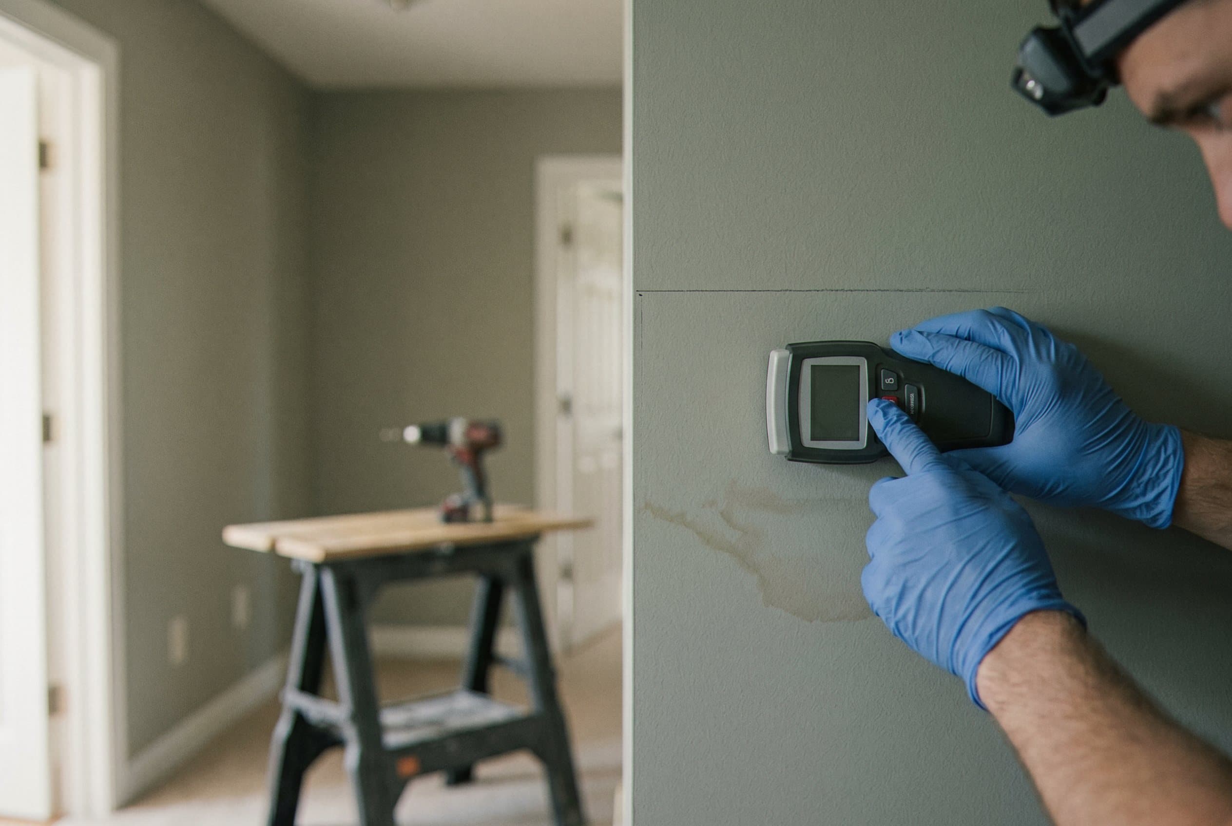 Technician meter checking drywall moisture level
